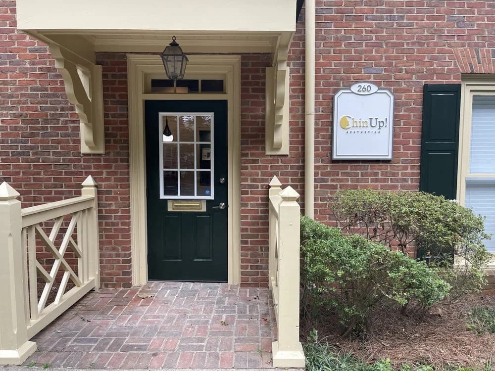 Decatur storefront entrance — dark green door, brick facade, Chin Up! signage